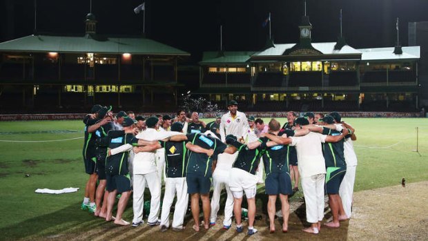 Nathan Lyon of Australia leads the team song on the pitch at midnight.