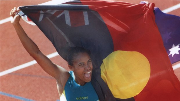 Cathy Freeman holds up the Aboriginal flag alongside the Australian flag after her 400m win at the 1994 Commonwealth Games.