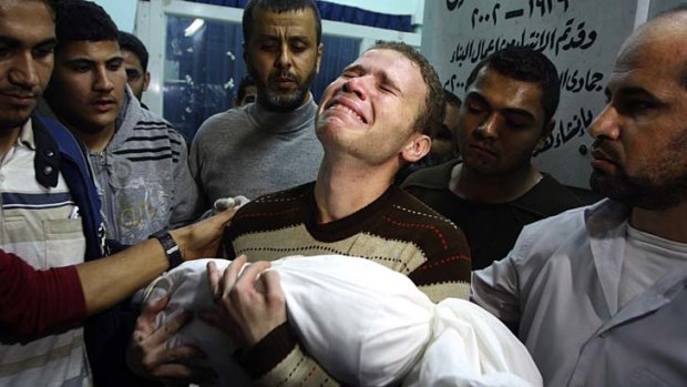 Victims on both sides &#8230; Jihad Masharawi holds his 11-month-old son's body at Shifa Hospital in Gaza City.