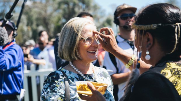 Lucy Turnbull is painted with ochre by Ngunnawal elder Tina Brown at the national citizenship ceremony in Canberra.