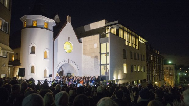 People gather as Norwegian Muslims create a human peace ring around the synagogue in Oslo.