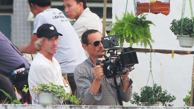 Attacked ... Director Michael Bay, left, assists the cameraman in filming <i>Transformers 4</i> in Hong Kong.