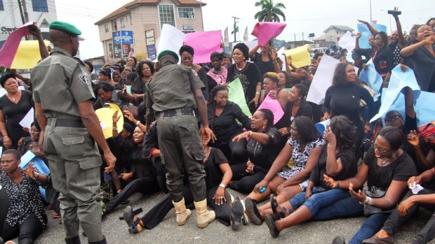 Nigerian troops try to disperse women from the All Progressives Congress,  party as they protest against voting irregularities in the presidential election in Port Harcourt, Nigeria, on Monday.