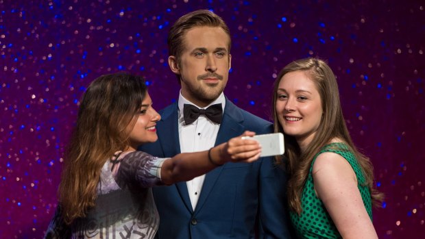 Fans pose with a Gosling wax figure at  Madame Tussaud's. 