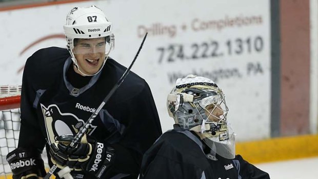 Sidney Crosby of the Pittsburgh Penguins skates behind goalkeeper Marc-Andre Fleury on the first day of training in Pittsburgh, Pennsylvania.