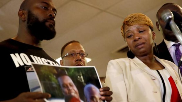 Lesley McSpadden (right) the mother of Michael Brown, with Mr Brown's father, Michael Brown snr holding a photo of their son at a news conference.