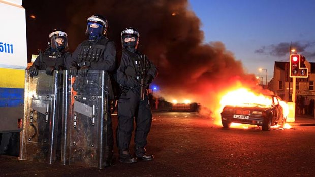 Anger unabated &#8230; police officers in riot gear stand near a burning hijacked car during continued clashes in East Belfast.