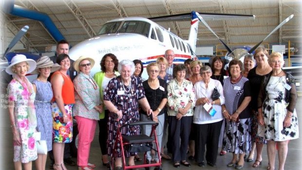 Members of the Broken Hill Women's Auxiliary stand in front of the Royal Flying Doctor plane that was named in their honour. Every year the women make Christmas puddings to raise funds. 