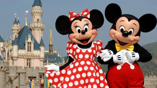Mickey Mouse and Minnie Mouse  in front of the Sleeping Beauty Castle in Hong Kong's Disneyland.