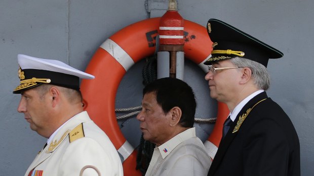 Philippine President Rodrigo Duterte, centre, walks with Russian Rear Admiral Eduard Mikhailov, left, and Russia's Ambassador to the Philippines Igor A. Khovaev.