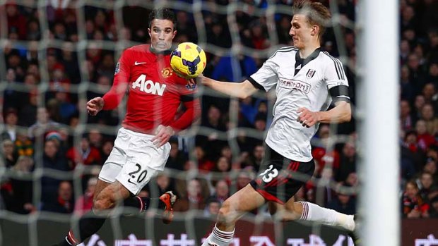 Fulham's Dan Burn (R) appears to handle the ball in the penalty box after a header on goal from Manchester United's Robin van Persie.