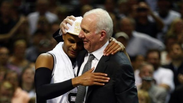 Patty Mills with San Antonio Spurs coach Gregg Popovich. Mills is expected to miss seven months after tearing the rotator cuff in his shoulder.