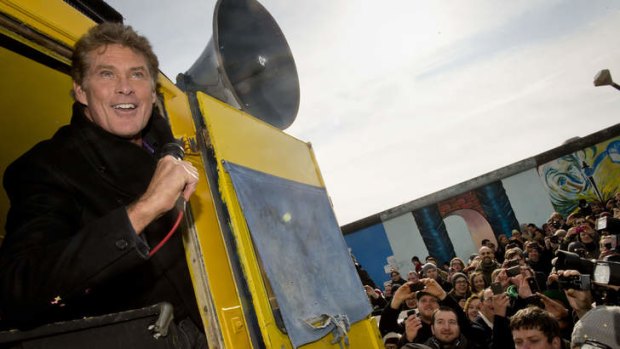 US actor and singer David Hasselhoff speaks to the crowd from a truck as he tours the East Side Gallery part of the remains of the former Berlin Wall.