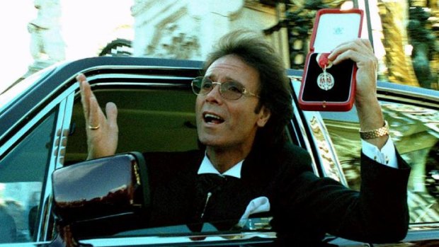 Celebrated: Cliff Richard is photographed at the gates of Buckingham Palace after receiving his knighthood from the Queen in 1995.
