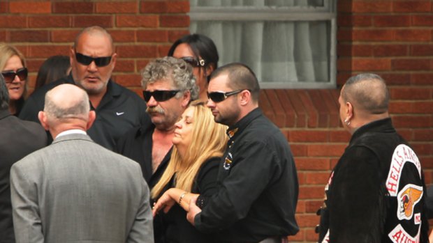 The mother of Anthony Zervas (third from right) is assisted by her son Peter Zervas, observed by president of the Guildford Chapter of Hells Angels, Derek Wainohu, at right.