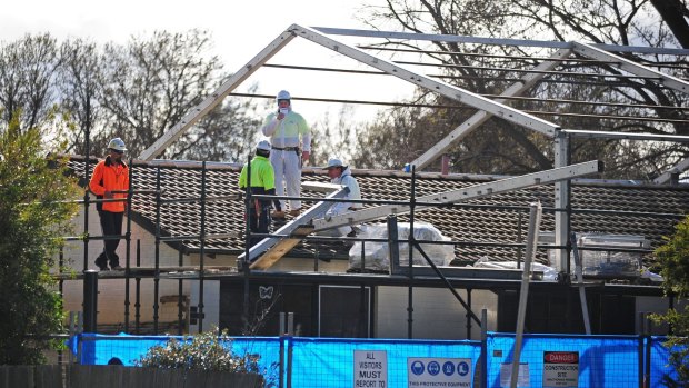 Asbestos removal from a house in Downer in 2013. Workers construct a steel frame where a plastic shield will be stretched over the house for the removal of asbestos. 