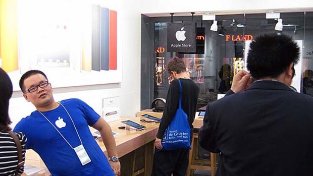 An employee wearing Apple's trademark blue T-shirt talking to a customer at an alleged fake Apple store in Kunming, China.