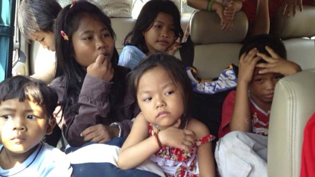 Children wait in a bus after being taken from the love in action orphanage