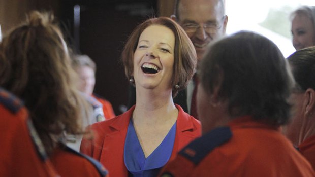 Julia Gillard shares a joke with volunteers at the Ipswich SES depot.