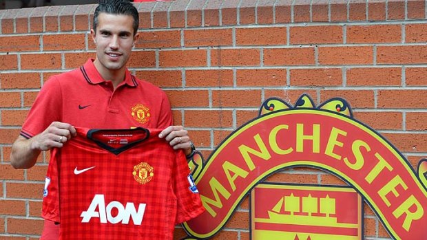 United he stands: Robin van Persie poses with his Manchester United shirt at Old Trafford.