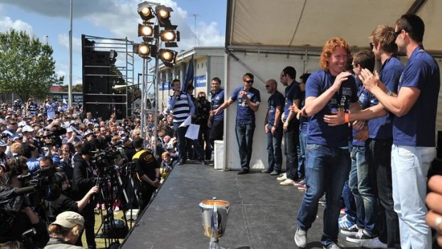 Cat walks ... Geelong skipper Cameron Ling strolls past his teammates with a grin at yesterday's family day celebration after the grand final win.