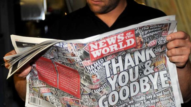Printer James Bradley reads the final edition of the British tabloid newspaper News of the World
