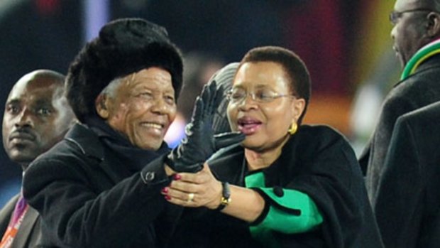 Nelson Mandela and wife Graca Machel greet the Soccer City crowd today.