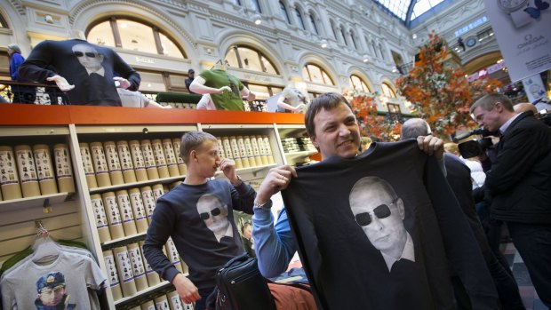 Popular figure ... Shoppers choose shirts bearing an image of Russian President Vladimir Putin at GUM (the State Department Store) in Moscow, Russia.