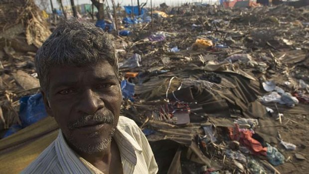 A fisherman stands amid the wreckage of the hut he used to occupy at Pattanambakam in Chennai, India on Sunday January 2, 2005.