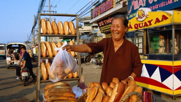 A woman from old Saigon sells crusty French breadsticks.