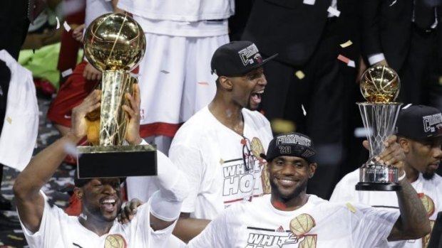 the Miami Heat's Dwyane Wade, left, holds Dwayne Wade with the NBA Championship Trophy in 2013.