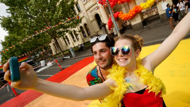 Joshua Burge and Natalia Quesnel from Spain pose for a selfie in Lygon Street.