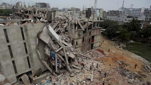 Hundreds dead ... Bangladeshi soldiers and rescue workers walk outside the collapsed building.