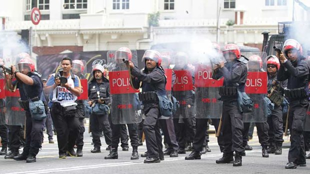 Malaysian police fire tear gas canisters at protesters in Kuala Lumpur.