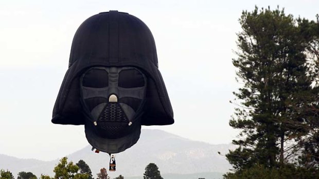 A hot air balloon shaped like Darth Vader's head floats above Canberra.