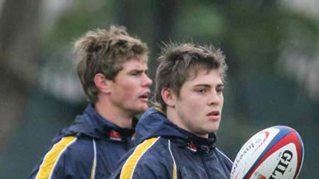 James O'Connor looks on during a Wallabies training session at Latymer Upper School in London. Behind him is Berrick Barnes.