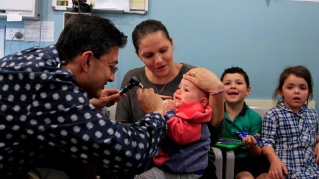 Budget blues: Dr Danish Khan examines one-year-old Luca at the Carnes Hill Medical Centre in Horningsea Park.
