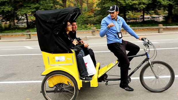 Tourists ride in a New York City pedicab through Central Park.
