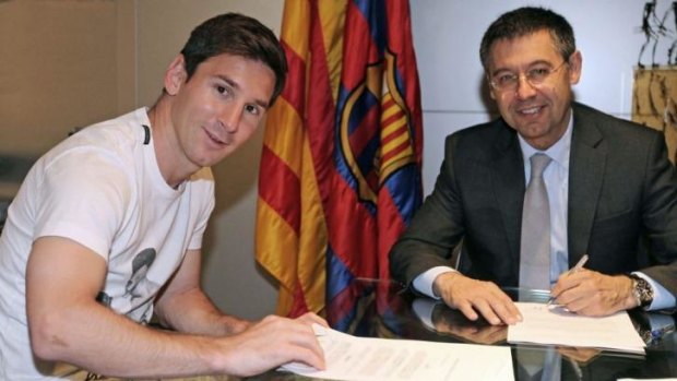Barcelona's Lionel Messi (L) signing his new contract with the Catalan club with FC Barcelona's president Josep Maria Bartomeu.