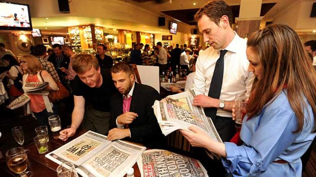 People in a London pub read the final edition of the News of The World.