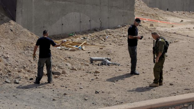 Under fire: Israeli security officials examine the scene of a rocket attack in Eilat. At least two rockets were fired at the southern resort city.