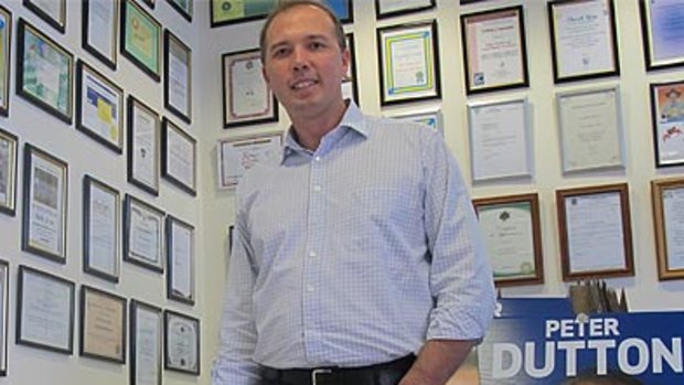 Peter Dutton in his Dickson electorate office, surrounded by certificates of appreciation from local community groups.