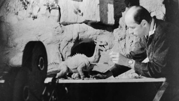 American animator and special effects creator Ray Harryhausen works with a figure of a dinosaur.