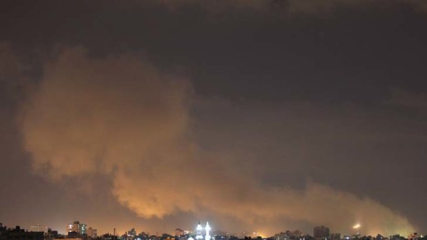 Retaliation ... a plume of smoke rises above Gaza City as Israeli air strikes hit.