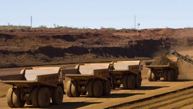 Haul trucks wait to be loaded with iron ore for China at a Fortescue Metals Group mine in West Australia.