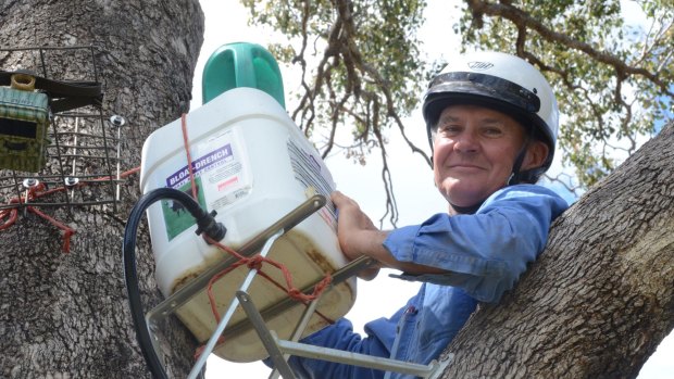 Gunnedah farmer Robert Frend refills a Blinky Drinker he designed to helps keep koalas hyrdrated. 