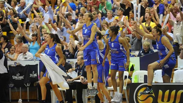 Spirited: Bendigo players and supporters jump for joy as they clinch the WNBL title.