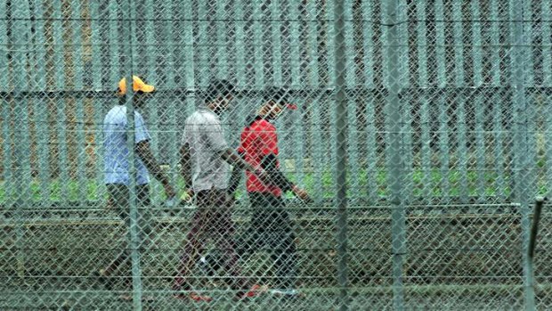 People walk behind the barbed wire fences at the Villawood Immigration Detention Centre in Sydney.