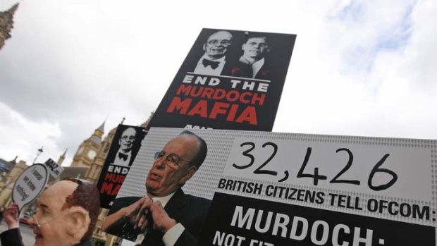 Threats ... protesters outside the Palace of Westminister this week carry banners denouncing Rupert Murdoch's ownership of British newspapers.