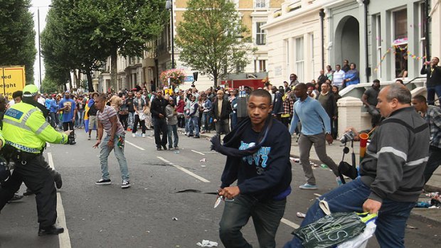 A man flees carrying a knife as a bystander tries in vain to trip him up after a stabbing at London's Notting Hill Festival.